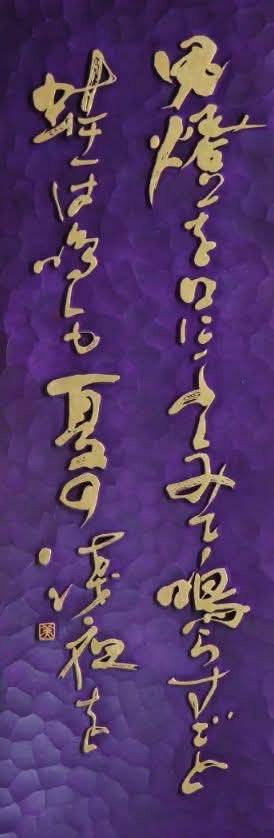 紫色の木地に金色の文字を刻した佐能寶咲の刻字作品